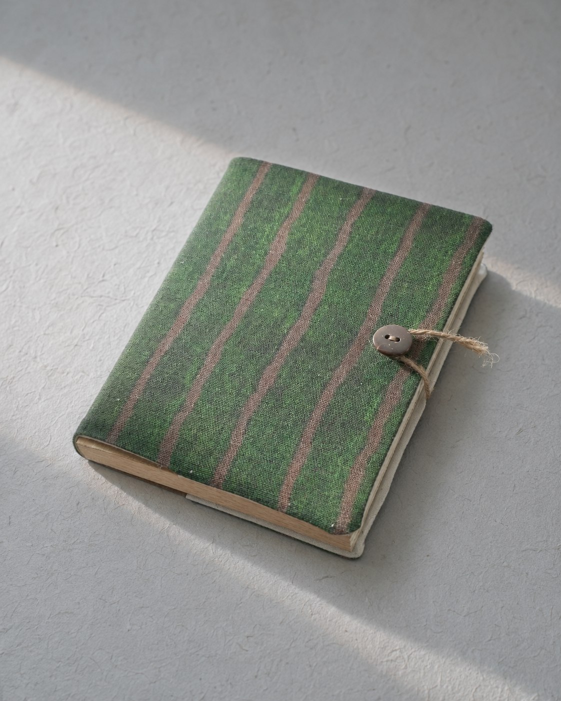 Acrehand green striped cloth cover notebook on a quiet tabletop